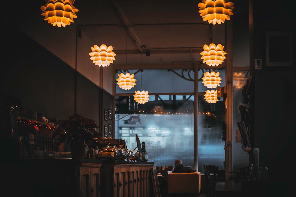 Salão da cantina à noite, com luminárias acesas